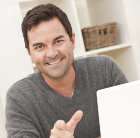 A man sitting at a table with his laptop.