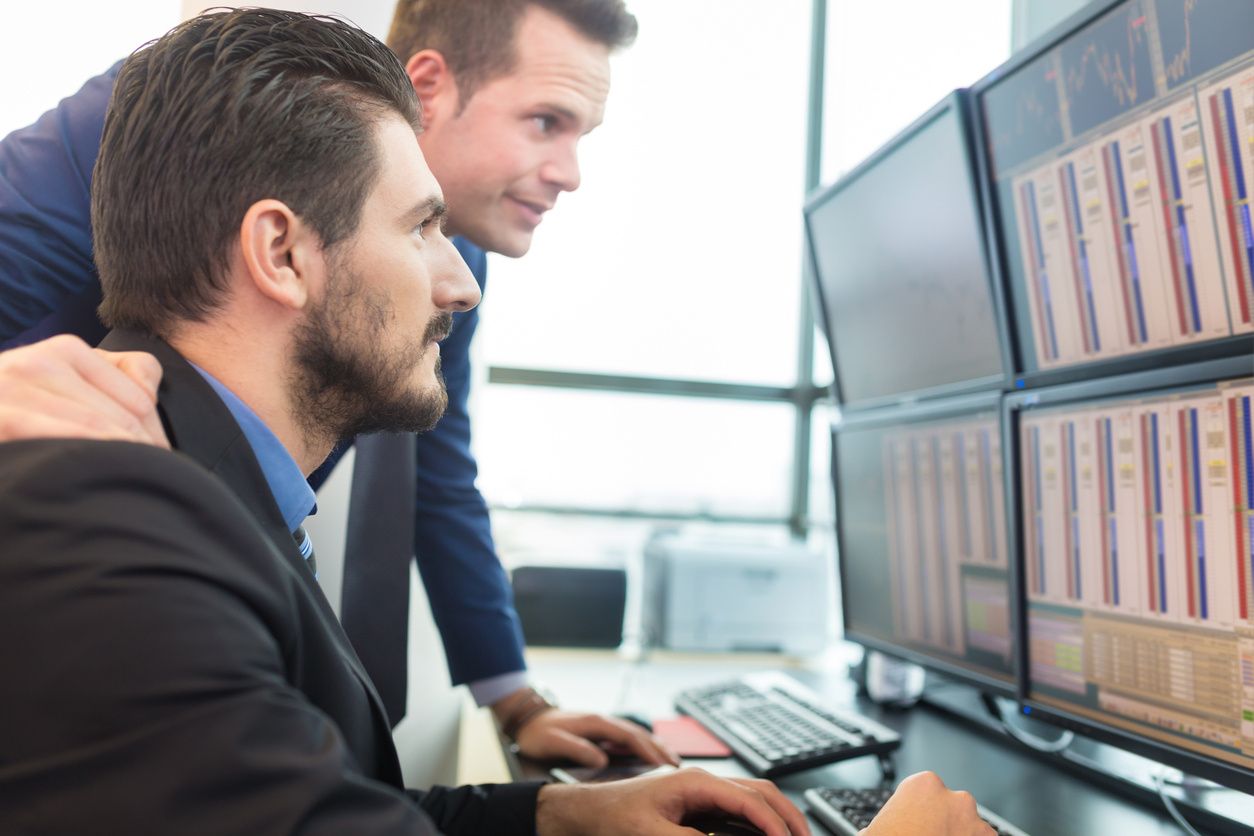 Two men looking at a computer screen.